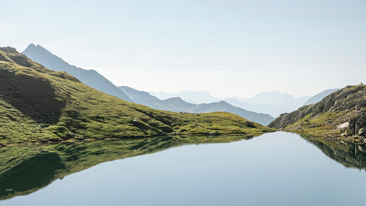 Landschaft mit See und Bergen.