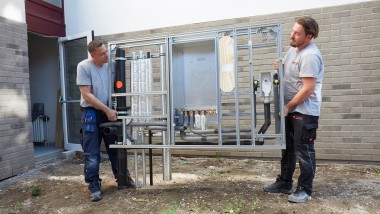 Installateure tragen einzelne Einheiten der Installationswand, Foto: Bosch