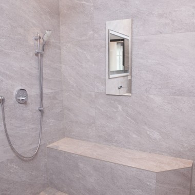 Ansicht der bodenebenen Dusche mit Sitzmöglichkeit und der verspiegelten Geberit Schiebetür. Ansicht der bodenebenen Dusche mit Sitzmöglichkeit und der verspiegelten Geberit Schiebetür.