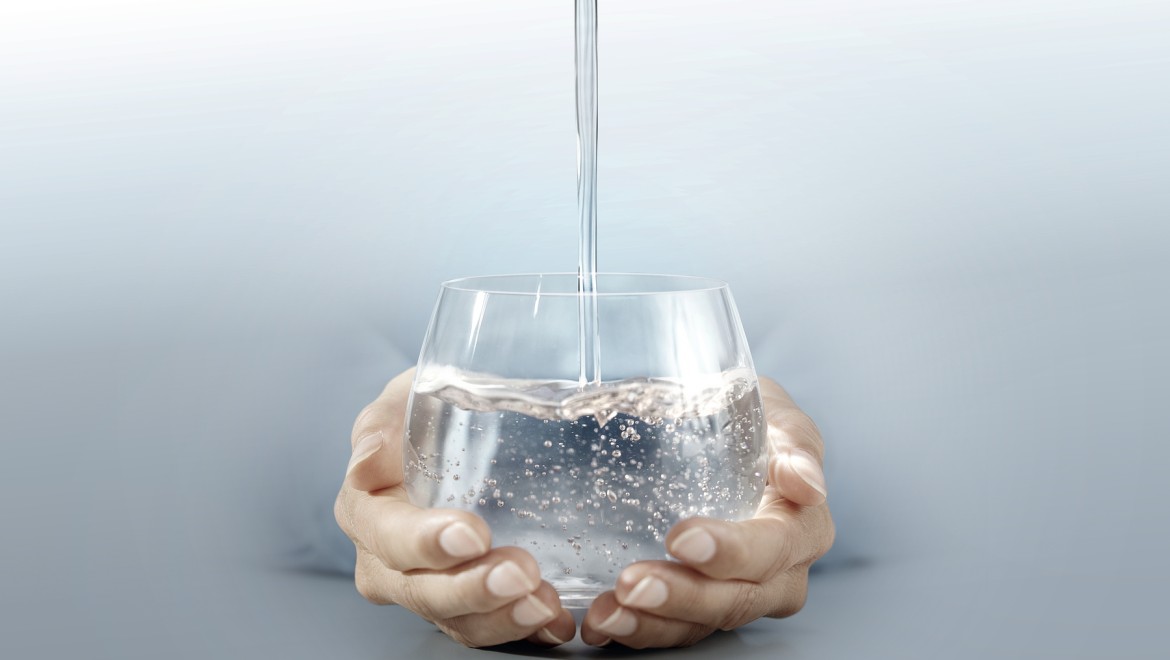 Person hält Wasserglas in ihren Händen Person hält Wasserglas in ihren Händen